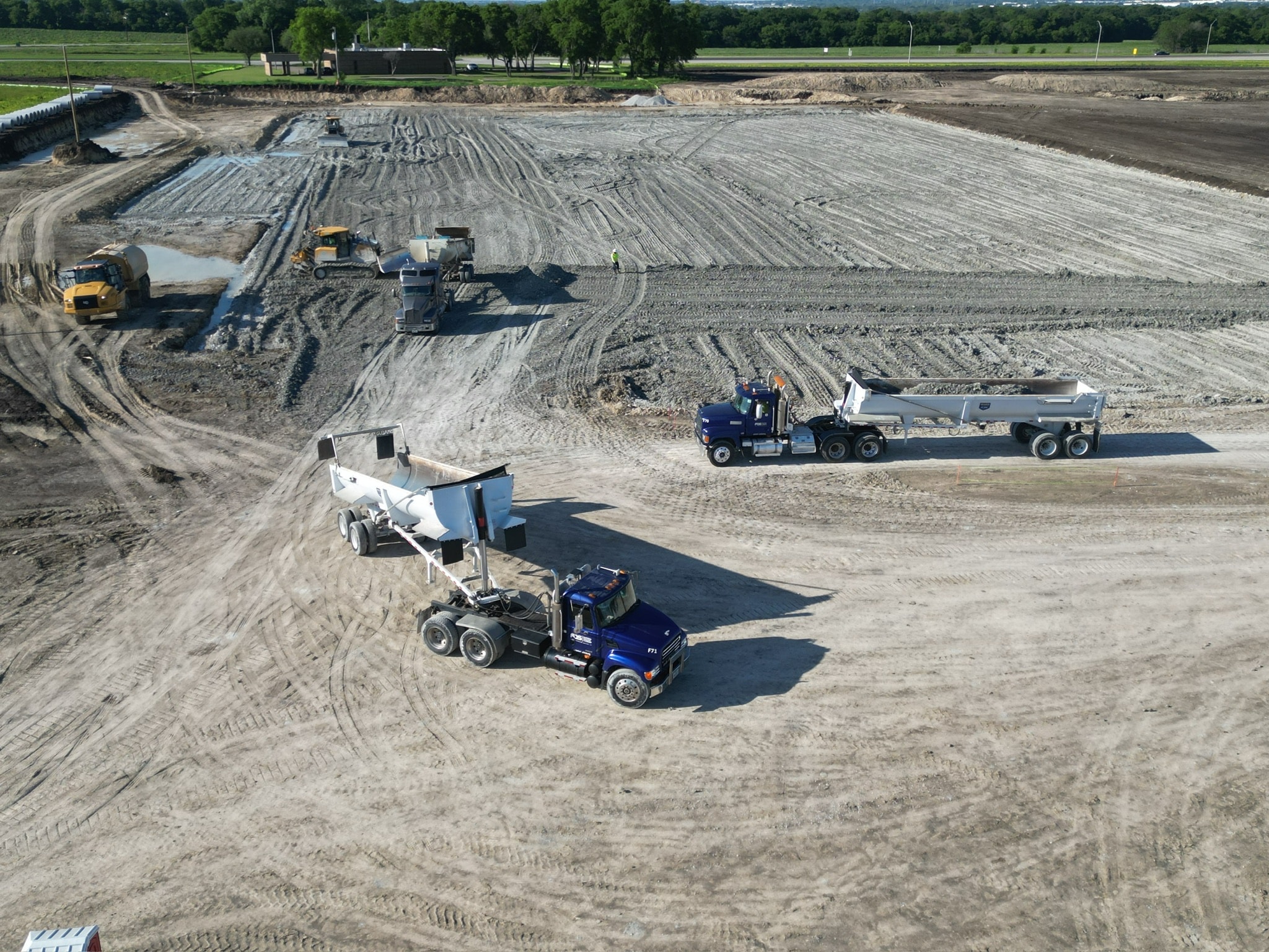 FOS Logistics trucks hauling material on a large earthwork project