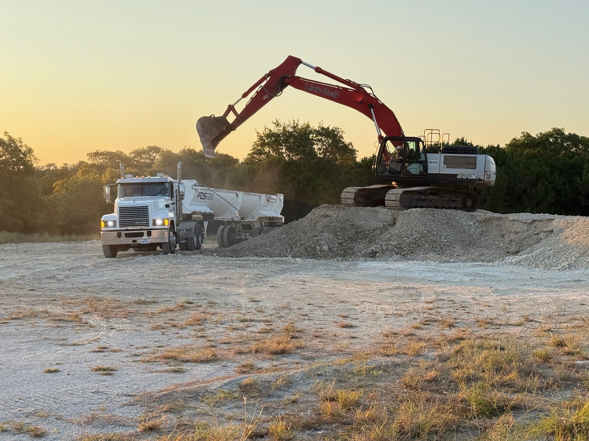 FOS Logistics truck being loaded with material by a wheel loader